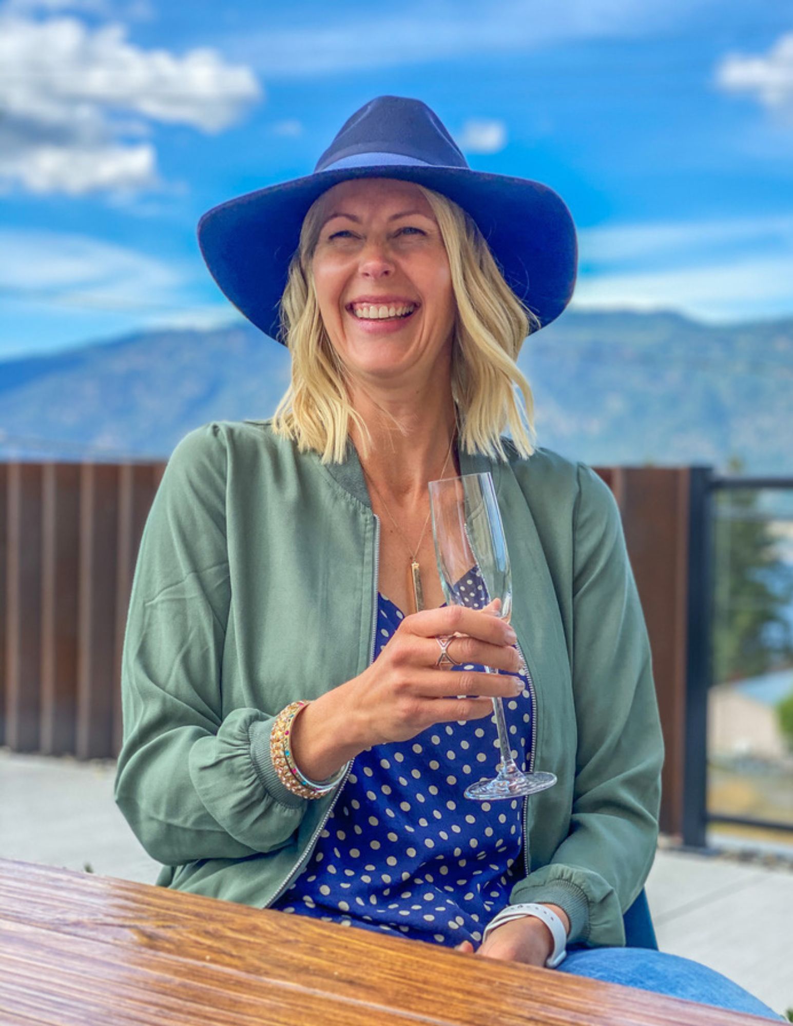 woman laughing holding champagne glass in wine country in british columbia